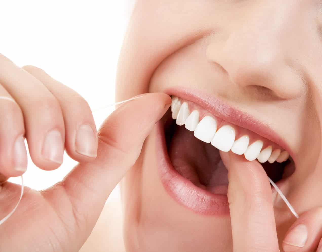 flossing teeth between gums cleaning bleeding vitamin lady hygiene tips clean tooth dental dentist woman intake increasing stop help brush